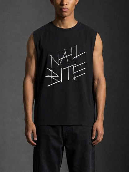 A man wearing a black sleeveless muscle tank top with a white graphic text print reading 'NAIL BITE' across the chest, paired with dark jeans, set against a dark gray studio background.